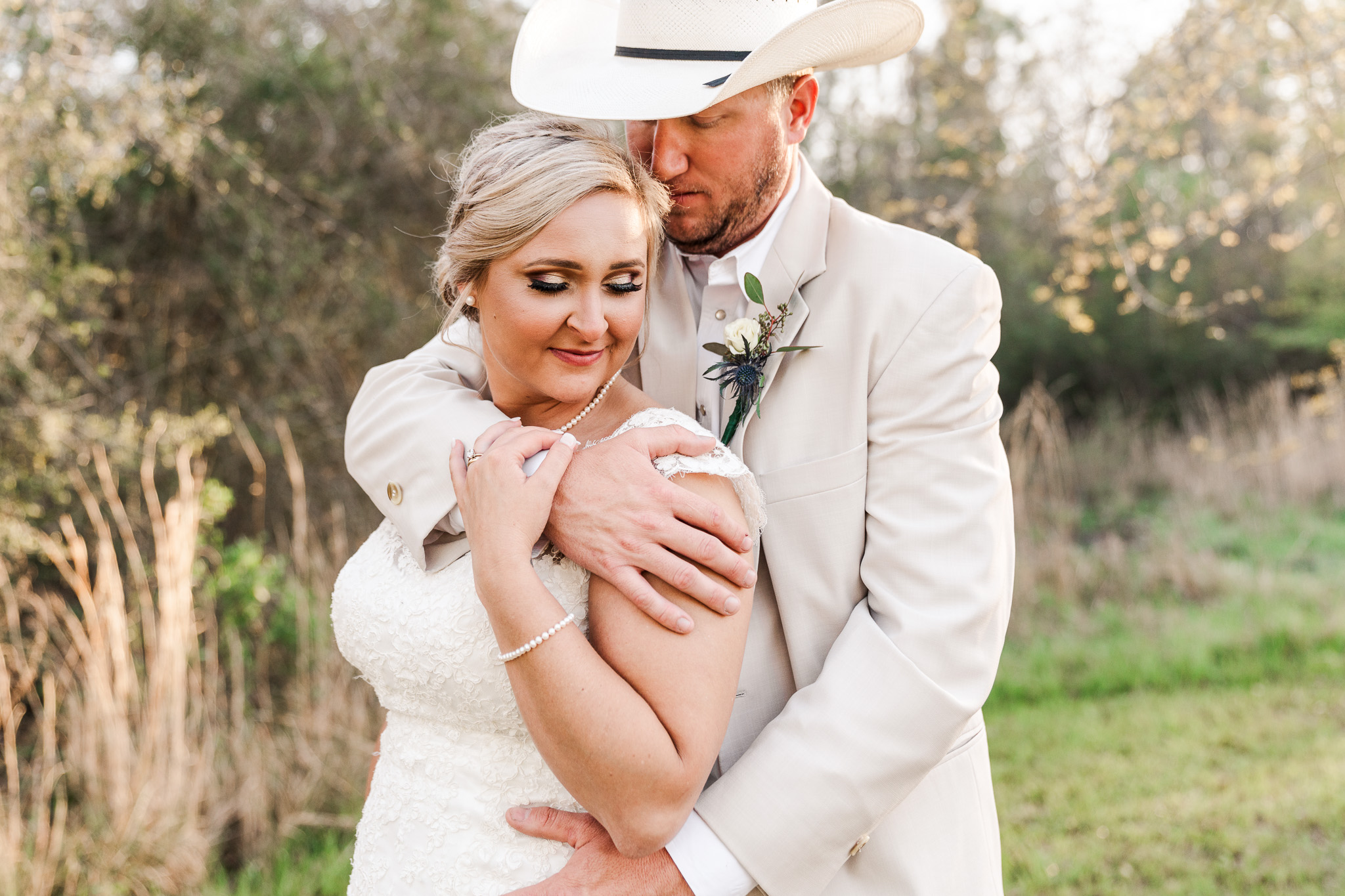 Groom holds his bride in a field at The Barn at Homestead wedding venue for their country southern Mississippi wedding video