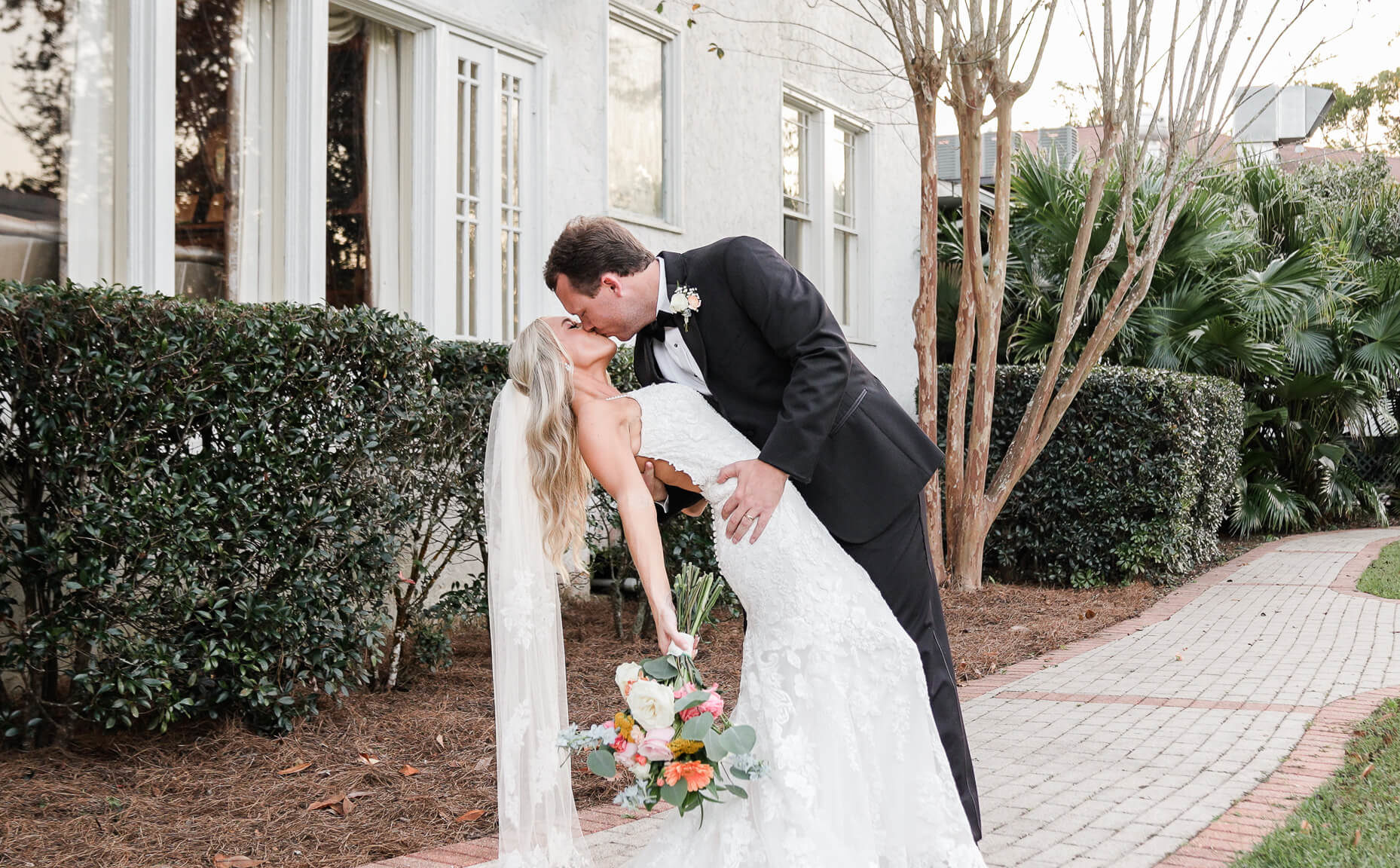 Groom dips bride for a kiss after their ceremony for their Oak Crest Mansion Inn wedding video