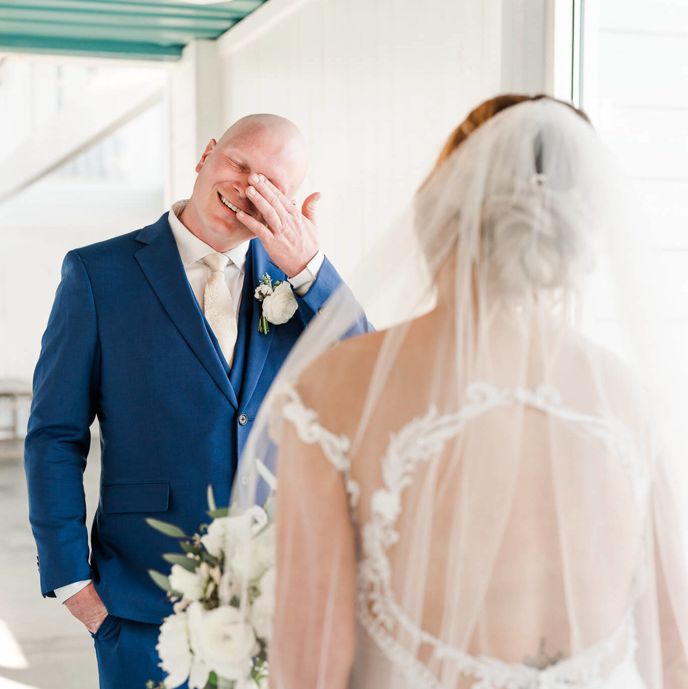 Emotional groom sees his bride for the first time during first look and is wiping his tears