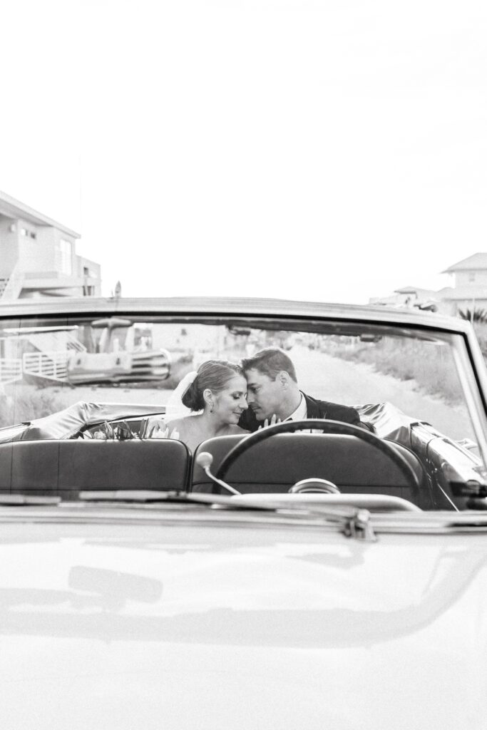 Husband and wife snuggle up in the back of a vintage Packard car