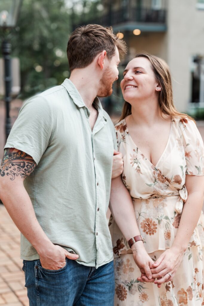Man and woman walk on the sidewalk and smile at each other