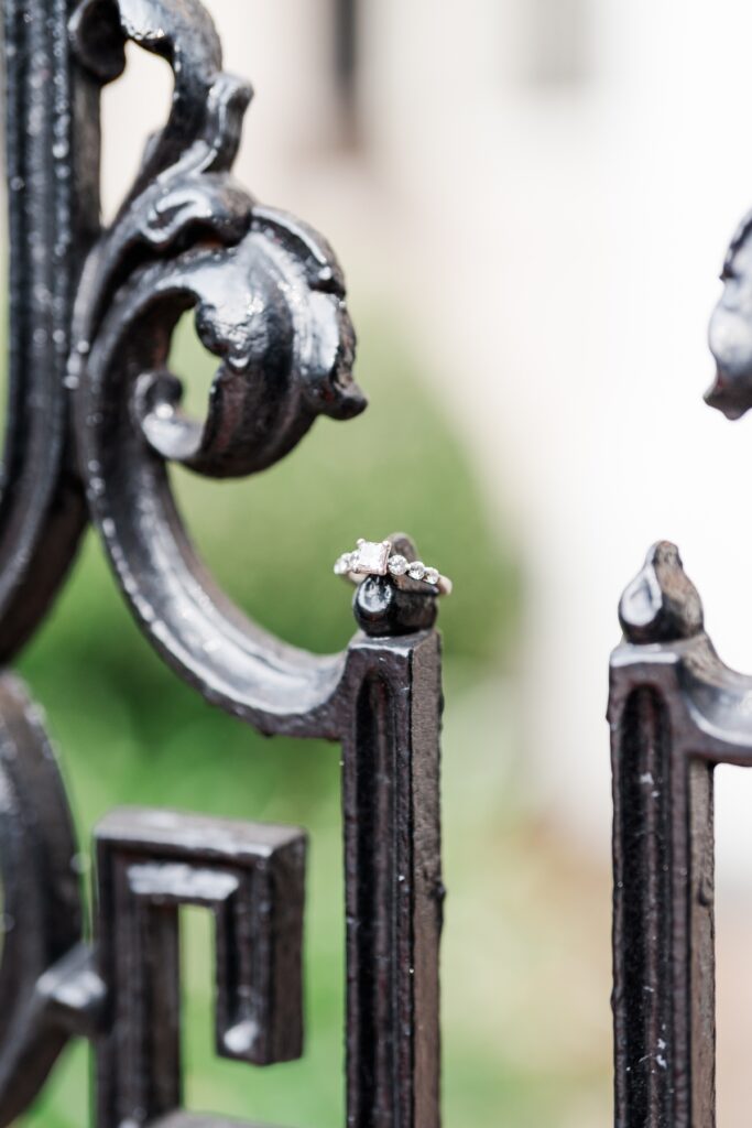 Engagement ring hangs on black iron fence detail at the historical Fort Conde Inn in Mobile, AL